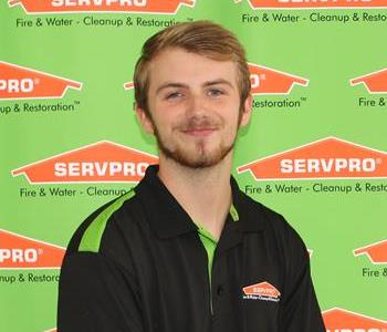 image of male sitting in front of SERVPRO backdrop