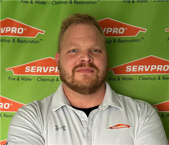 man in front of SERVPRO banner