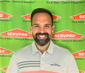 man in front of servpro banner